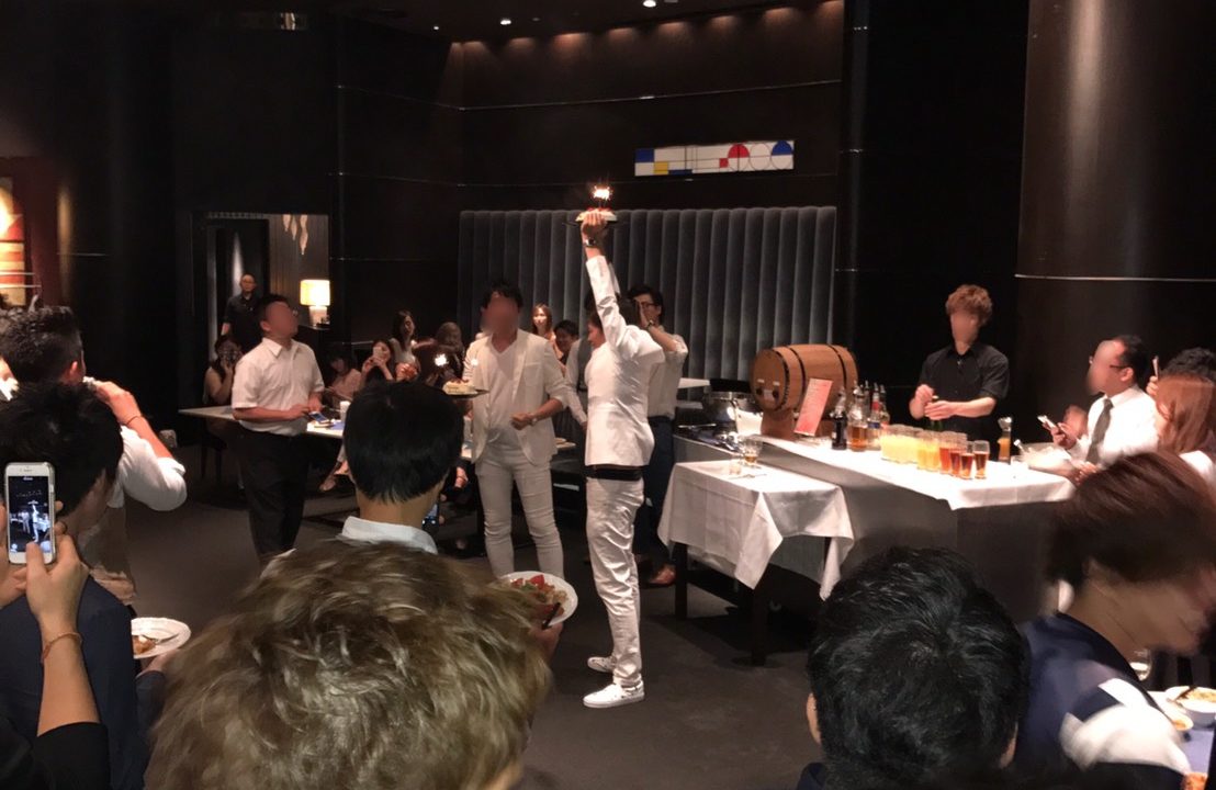 数十人の若者がドレスコードを着て誕生日会をしている風景
